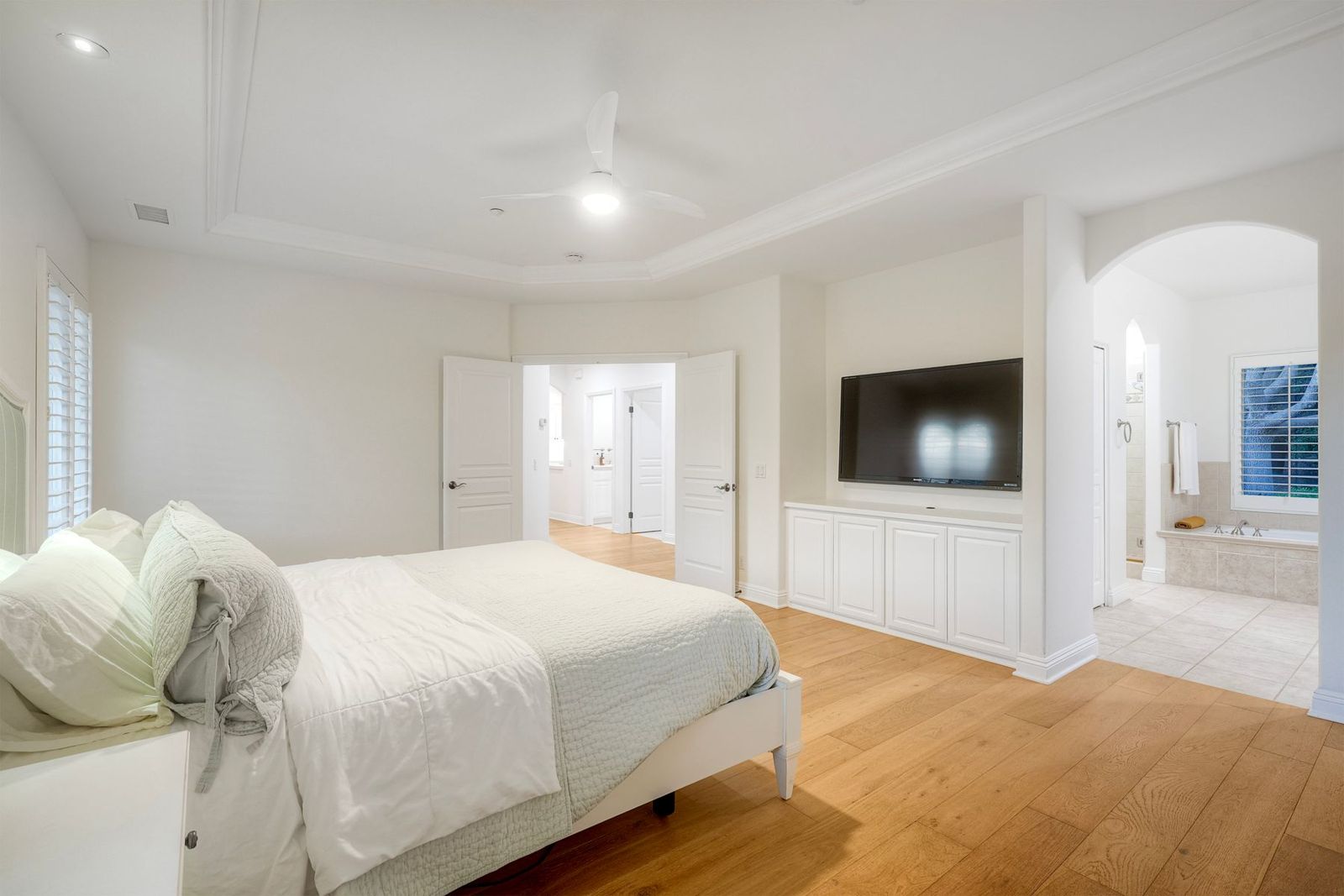Primary bedroom with arched opening to the bath